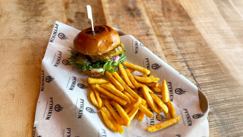 Cheeseburger and fries on a wooden table.